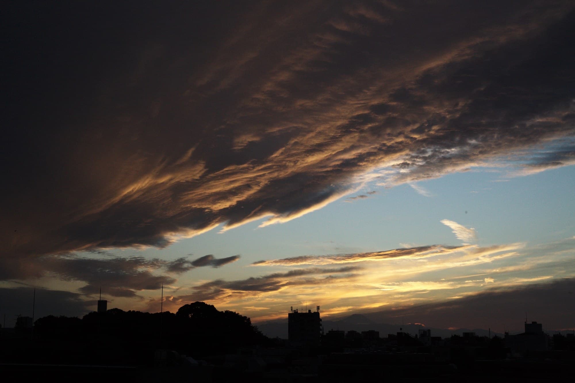 夕焼けの雲と街並みのシルエット